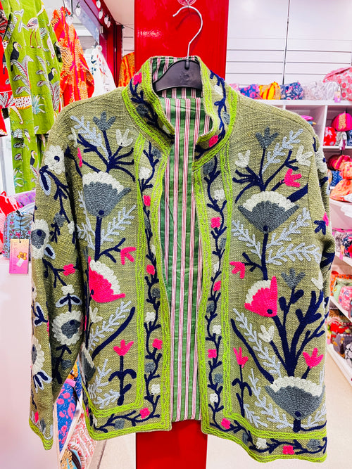 Suzani embroidered jacket detail - close-up of colorful embroidery work on cotton fabric