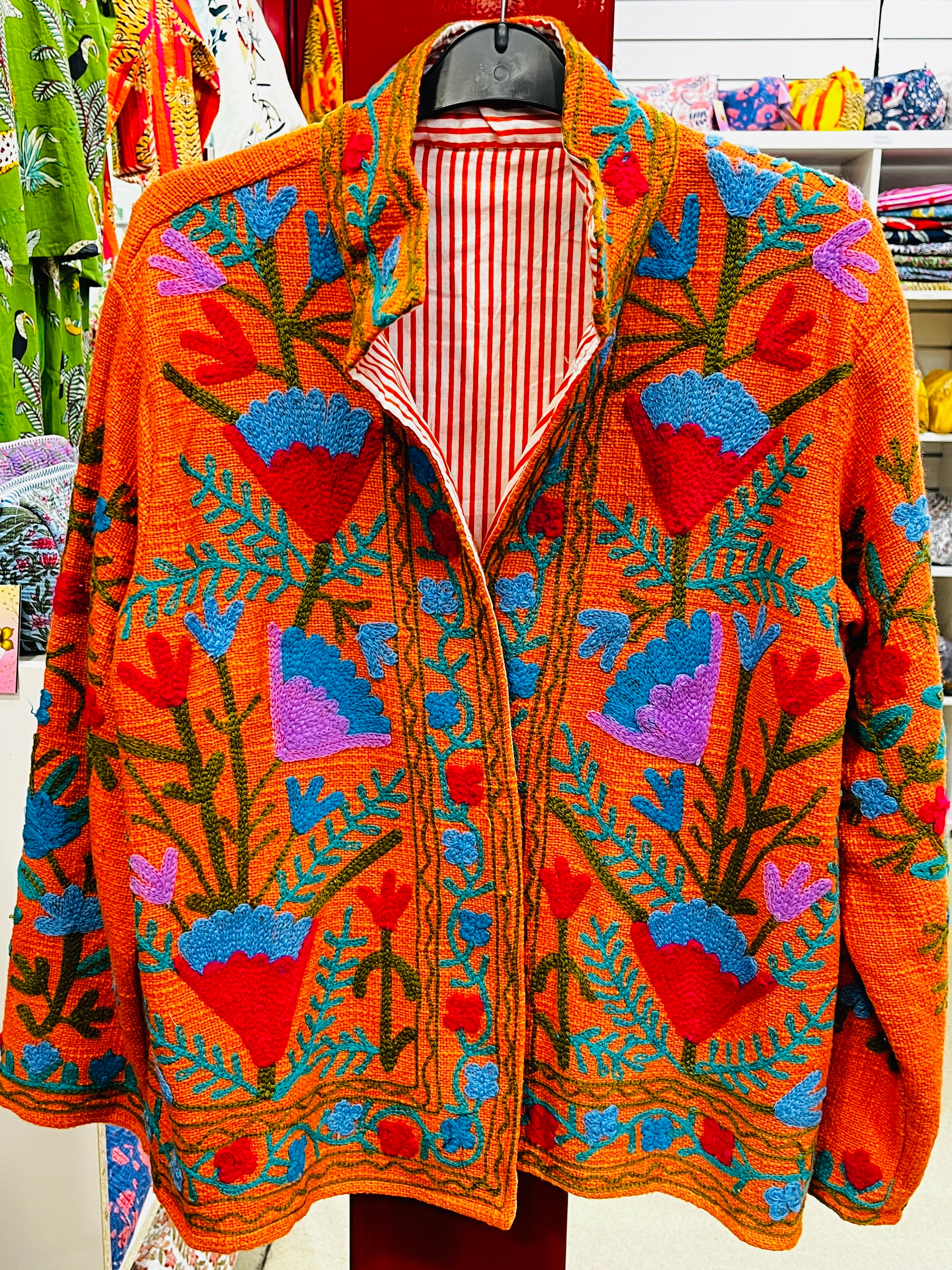 Suzani embroidered jacket detail - close-up of colorful embroidery work on cotton fabric