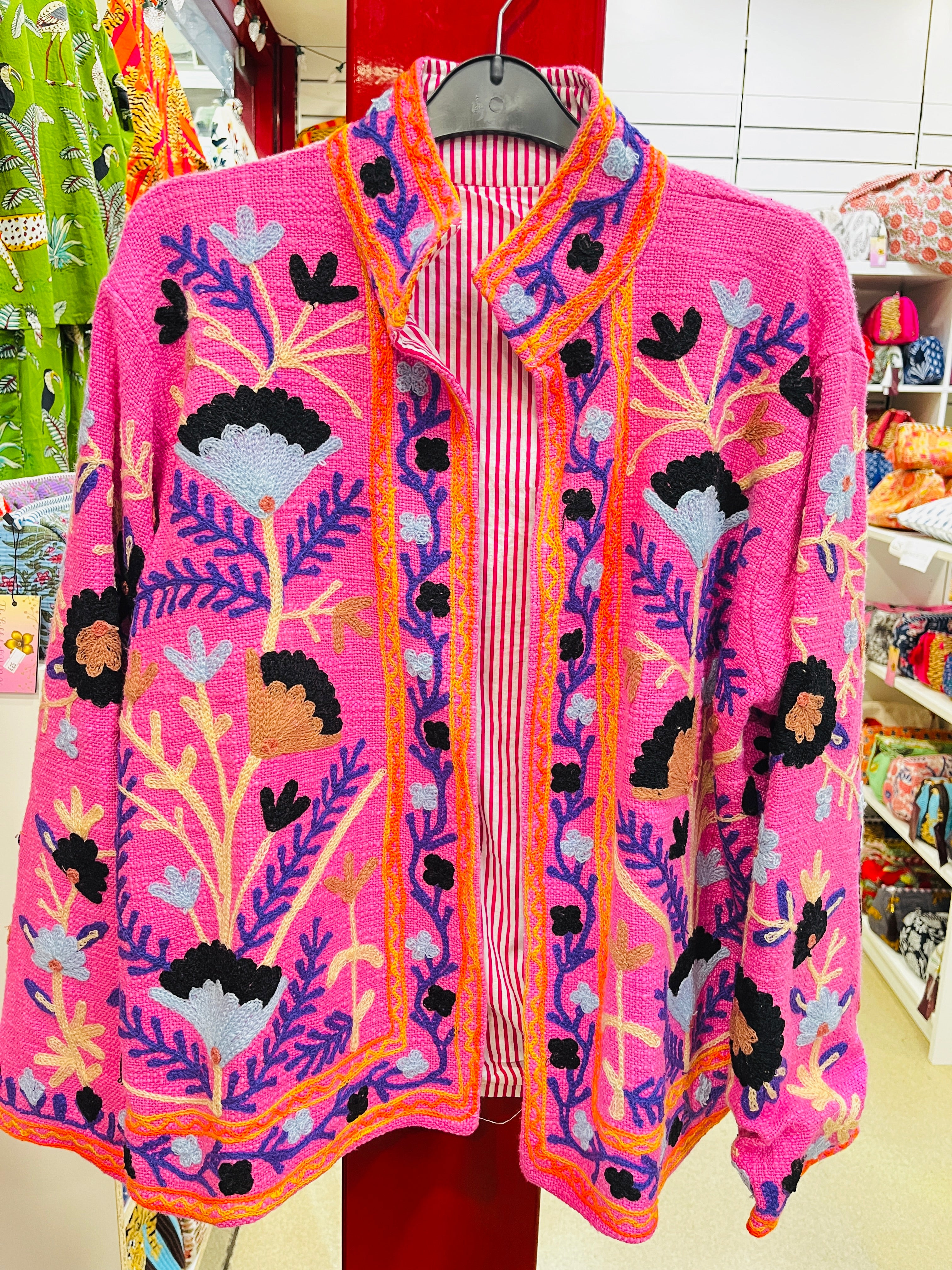 Suzani embroidered jacket detail - close-up of colorful embroidery work on cotton fabric